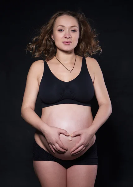 Fotografiar a una mujer embarazada en un estudio en diferentes posiciones —  Fotos de Stock
