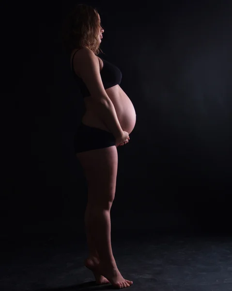 Photographing a pregnant woman in a studio in different positions — Stock Photo, Image