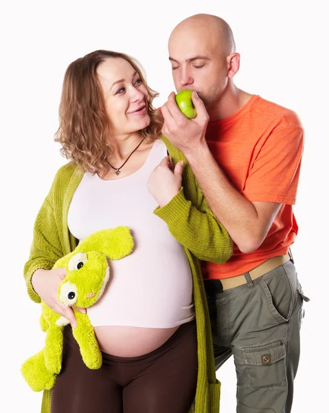 Беременная женщина с мужем с зеленым яблоком — стоковое фото