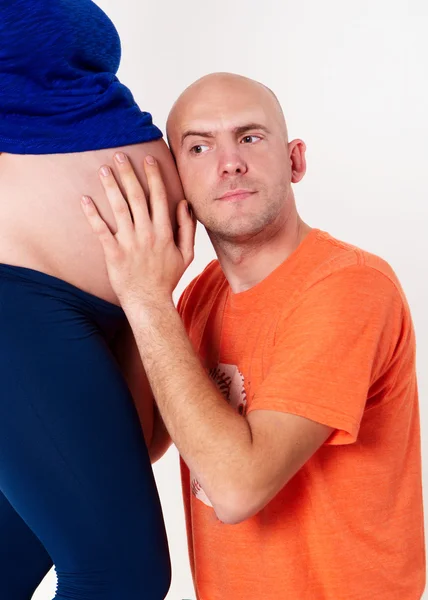 The husband overhears in the belly of his wife — Stock Photo, Image
