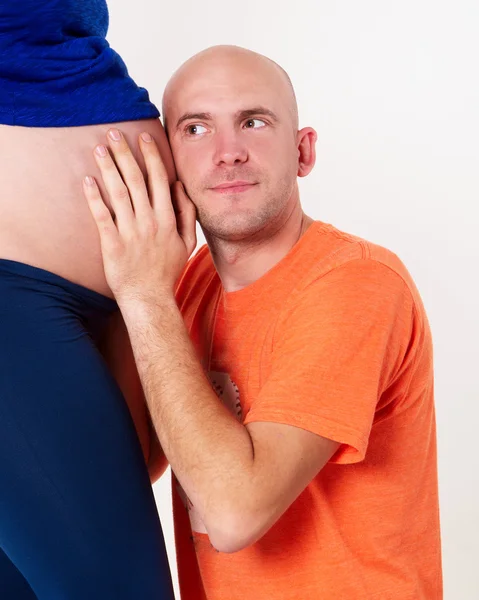 The husband overhears in the belly of his wife — Stock Photo, Image