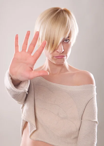 Blondynka z krótkimi włosami trzymając rękę w geście protestu na białym tle — Zdjęcie stockowe