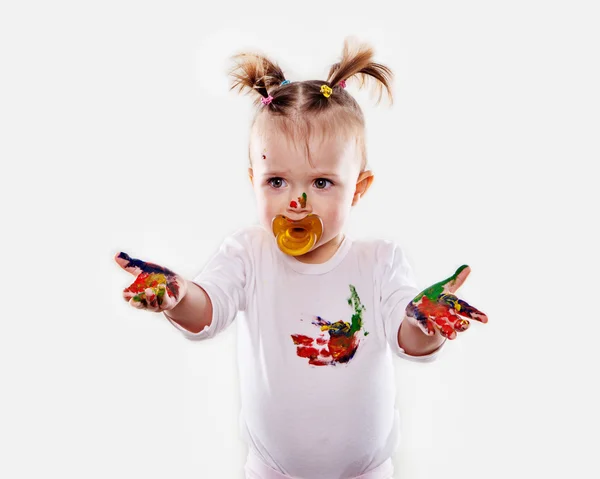 La niña con un chupete en gouache manos sucias y camisa aislada —  Fotos de Stock