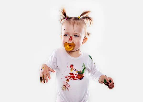 A menina com uma chupeta em guache sujou mãos e camisa isolada — Fotografia de Stock