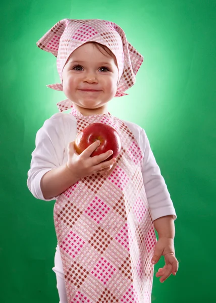La bambina con un fazzoletto e un grembiule da cucina che tiene un vegetale isolato — Foto Stock