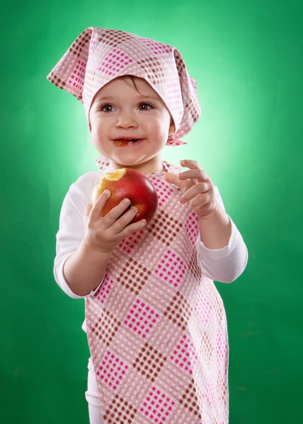 The baby girl with a kerchief and kitchen apron holding an vegetable isolated — Stock Photo, Image