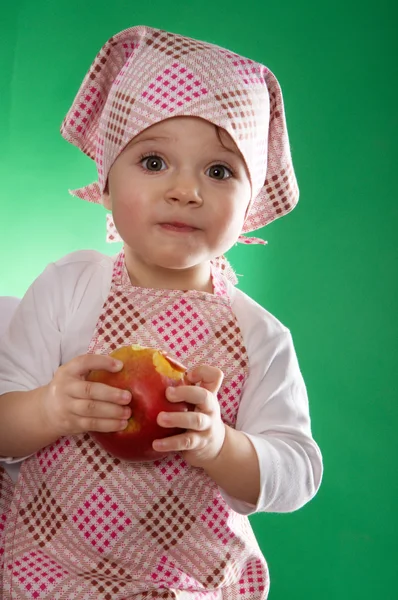 La bambina con un fazzoletto e un grembiule da cucina che tiene un vegetale isolato — Foto Stock