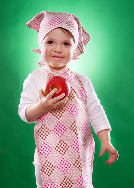 La bambina con un fazzoletto e un grembiule da cucina che tiene un vegetale isolato — Foto Stock