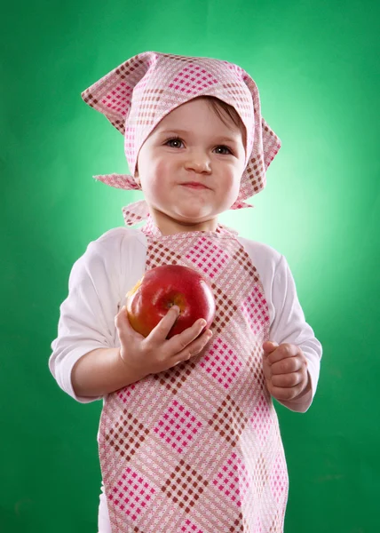 The baby girl with a kerchief and kitchen apron holding an vegetable isolated — Stock Photo, Image