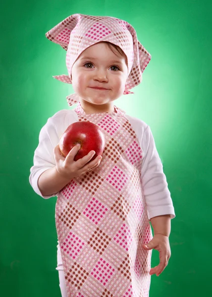 The baby girl with a kerchief and kitchen apron holding an vegetable isolated — Stock Photo, Image