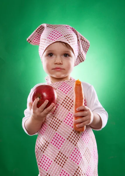 Девочка с платком и кухонным фартуком держит изолированный овощ — стоковое фото