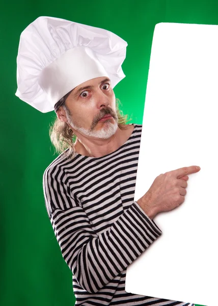De man met grijze baard in een matroos pak en hoed chef-kok wijst een vinger op de billboard geïsoleerd — Stockfoto