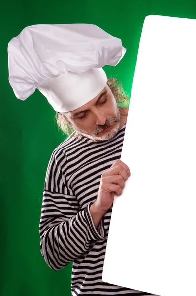 Человек с седой бородой в матросском костюме и шляпе шеф-повар показывает пальцем на рекламный щит изолирован — стоковое фото