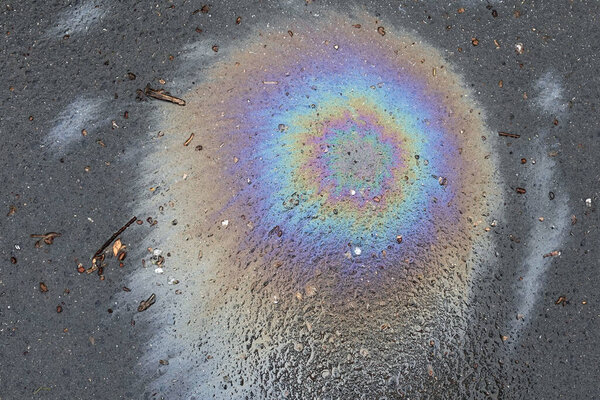 Утечка нефти и обломков на асфальте. Абстрактный фон.