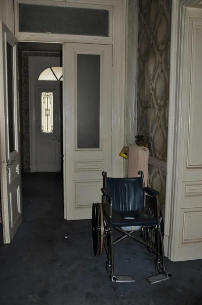 Cadeira de rodas em casa abandonada — Fotografia de Stock