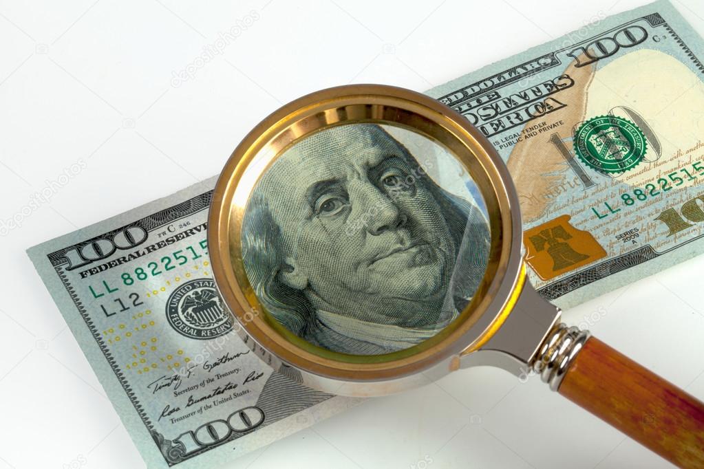 Hundred American dollars under magnifying glass