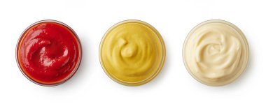 Üç farklı sos kasesi. Ketçap, mayonez ve hardal. Fast food sargıları beyaz arka planda izole, üst manzara