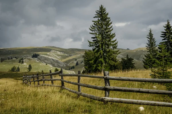 Old fence in the mountain village. Rural landscape in autumn.