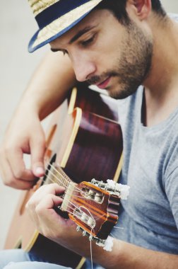 Adam gitar çalıyor.