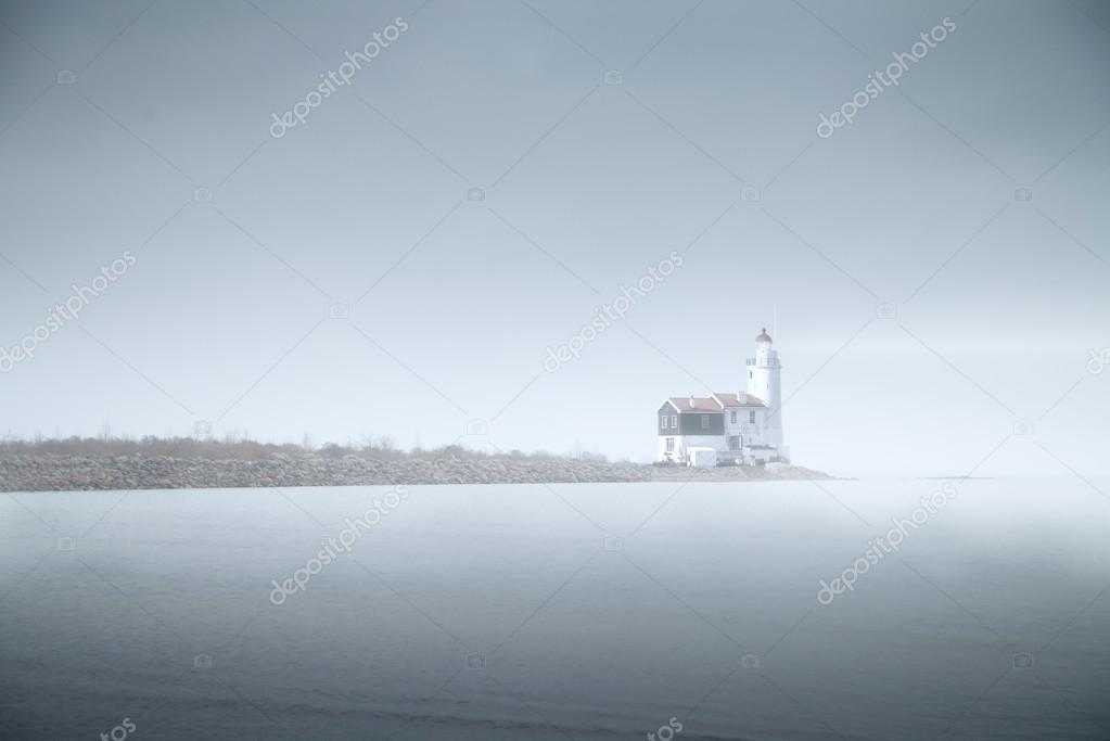 lighthouse in the fog is on the pier into the sea. mystical land