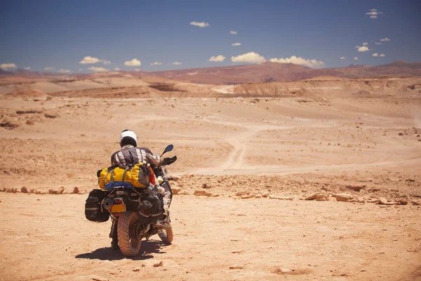 Rider reist de Atacama woestijn op een motorfiets. — Stockfoto