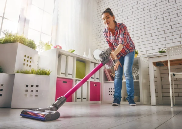 Woman vacuums the floor — Stock Photo, Image