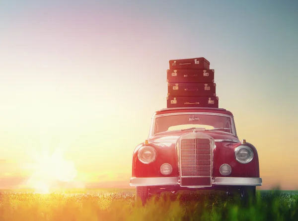 suitcases are on roof of car.