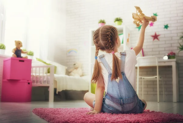 Девушка играет с игрушечным самолетом — стоковое фото