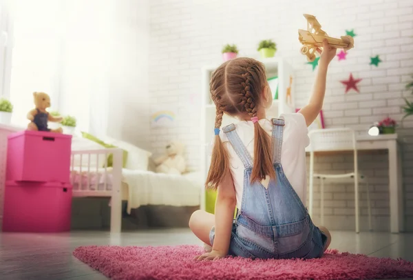 Mädchen spielt mit Spielzeugflugzeug — Stockfoto