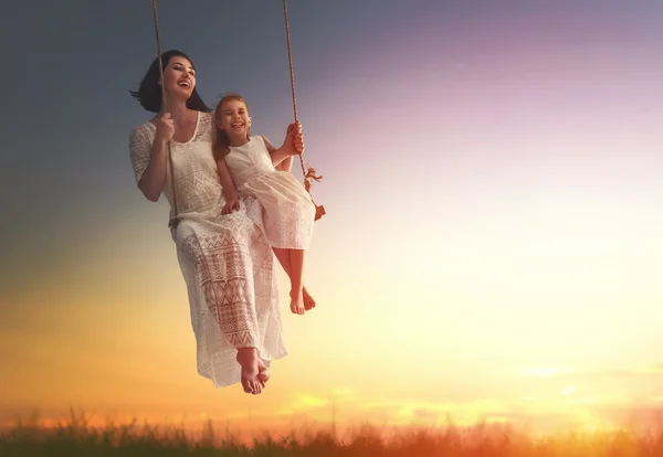 Mãe e filha balançando em balanços — Fotografia de Stock