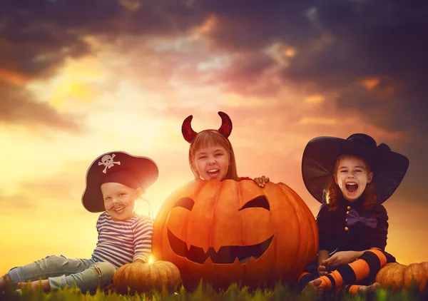 Kinderen en pompoenen op halloween — Stockfoto
