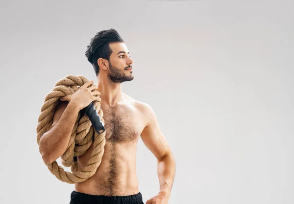 Atletische Jongeman Doen Crossfit Oefeningen Met Een Touw Grijze Achtergrond — Stockfoto