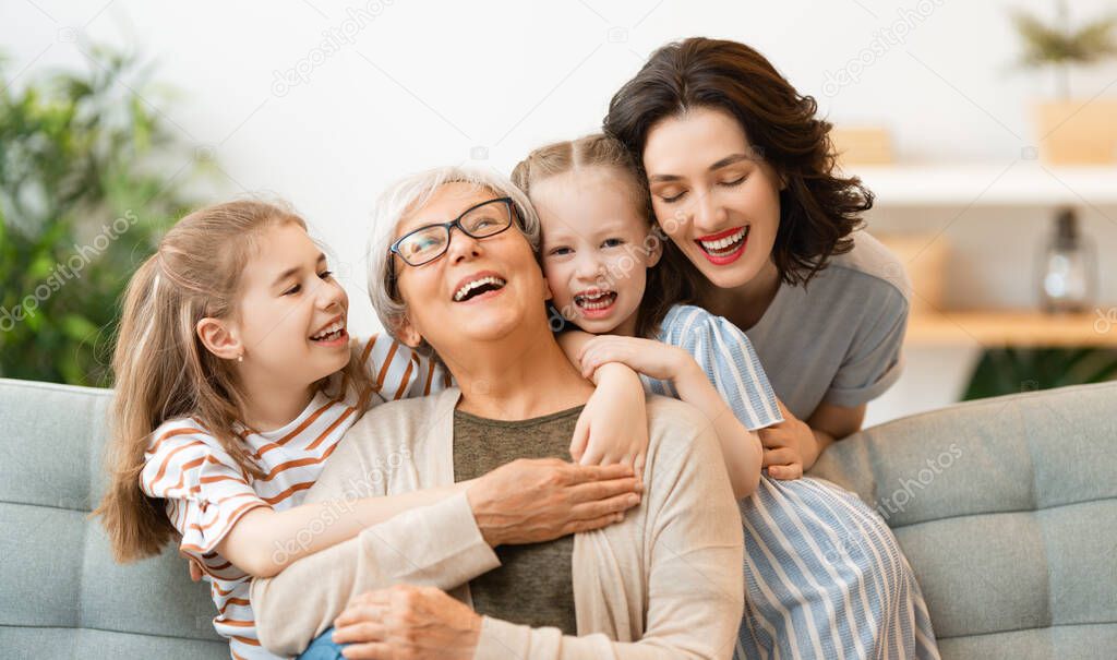 A nice girls, their mother and grandmother enjoying spending time together at home. 