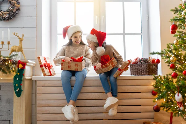 メリークリスマスとハッピーホリデー 陽気なかわいい子供たちの女の子の贈り物を開きます 子供たちは午前中に木の近くで楽しんでいます プレゼント付きの家族を愛する — ストック写真