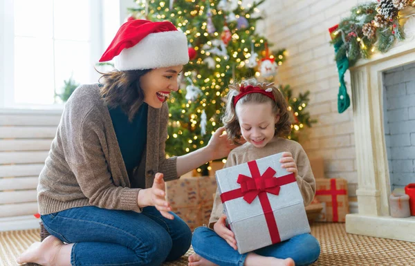 圣诞快乐 节日快乐 快乐的妈妈和她可爱的女儿交换礼物 父母和小孩在树旁玩得开心 有礼物在房间里的爱的家庭 — 图库照片
