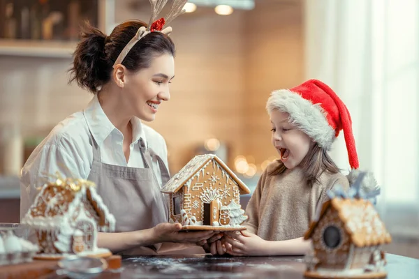 メリークリスマスとハッピーホリデー 家族の準備休日の食べ物 母と娘がジンジャーブレッドハウスを調理 — ストック写真