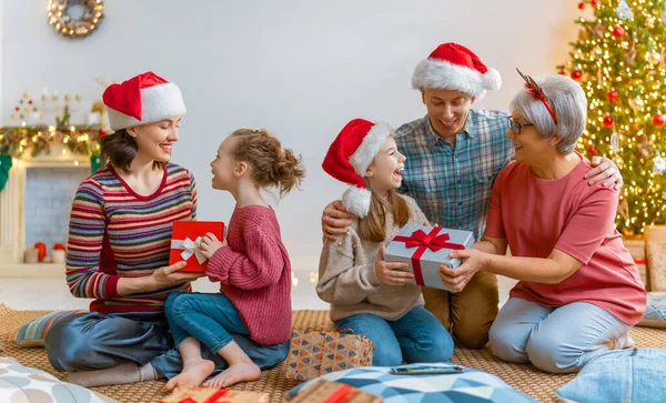 圣诞快乐 节日快乐 妈妈和孩子们交换礼物 父母和女儿在室内的树上玩得很开心 有礼物在房间里的爱的家庭 — 图库照片