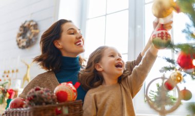 Mutlu Noeller ve mutlu tatiller! Anne ve kızı kapalı alanda ağacın yanında. Noel 'den önceki sabah. Portre seven aile. Yakın çekim.. 