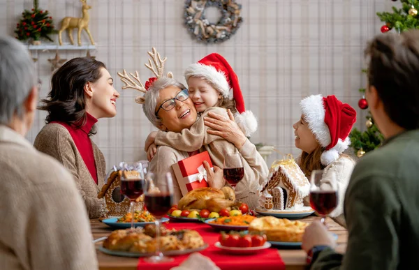 メリークリスマス 幸せな家族は家で夕食を食べている ツリーの近くでお祝いの休日と団結 — ストック写真