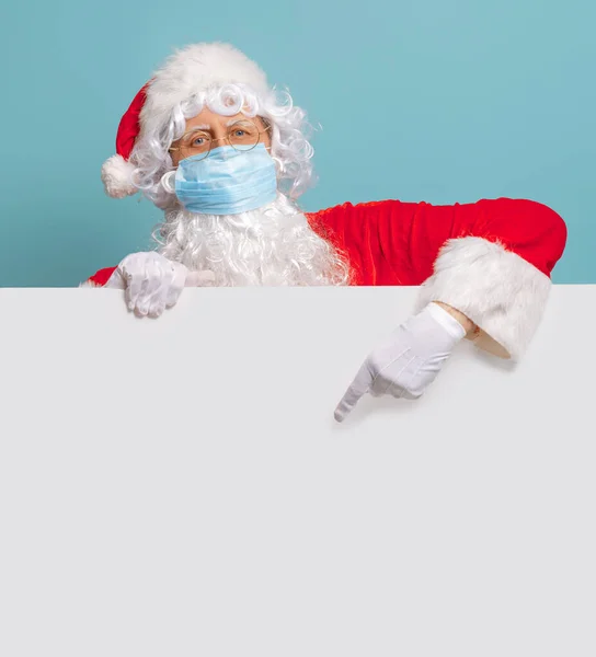 メリークリスマスとハッピーホリデー 明るい色の背景に顔のマスクでサンタクロース Covid 2019 — ストック写真