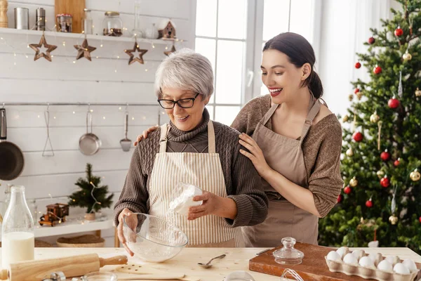 メリークリスマスとハッピーホリデー 家族の準備休日の食べ物 母親と娘がジンジャーブレッドハウスを調理 — ストック写真