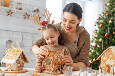 Mutlu Noeller ve mutlu tatiller. Aile yemeği hazırlama. Anne ve kız zencefilli ekmek evi pişiriyor..