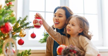 Mutlu Noeller ve mutlu tatiller! Anne ve kızı kapalı alanda ağacın yanında. Noel 'den önceki sabah. Portre seven aile. Yakın çekim.. 