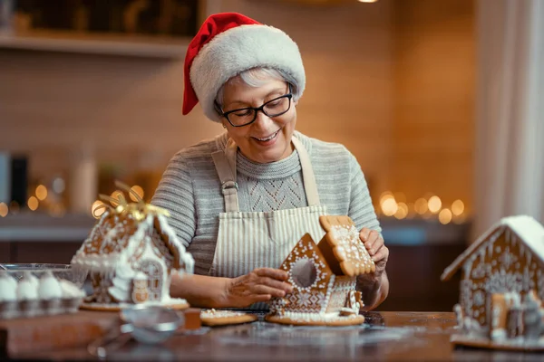 メリークリスマスとハッピーホリデー 家族の準備休日の食べ物 女性の料理 ジンジャーブレッドハウス — ストック写真