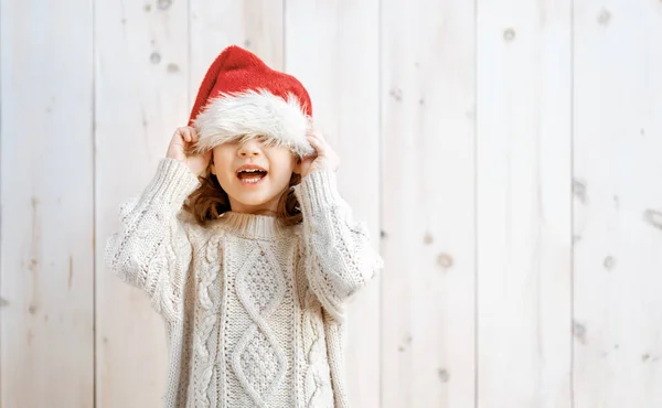 Szczęśliwa Dziewczynka Kapeluszu Mikołaja Białym Drewnianym Tle Boże Narodzenie — Zdjęcie stockowe