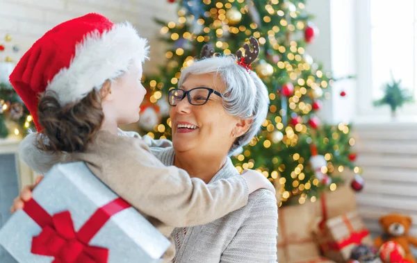 크리스마스 홀리데이 즐거운 할머니와 귀여운 손녀가 선물을 할머니와 아이들은 근처에서 — 스톡 사진