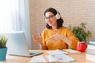 Genç kadın bilgisayarını uzaktan konuşma ve görüntülü konuşma için kullanıyor.. 