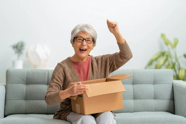 Krásná Starší Žena Drží Lepenkovou Krabici Sedí Pohovce Doma — Stock fotografie