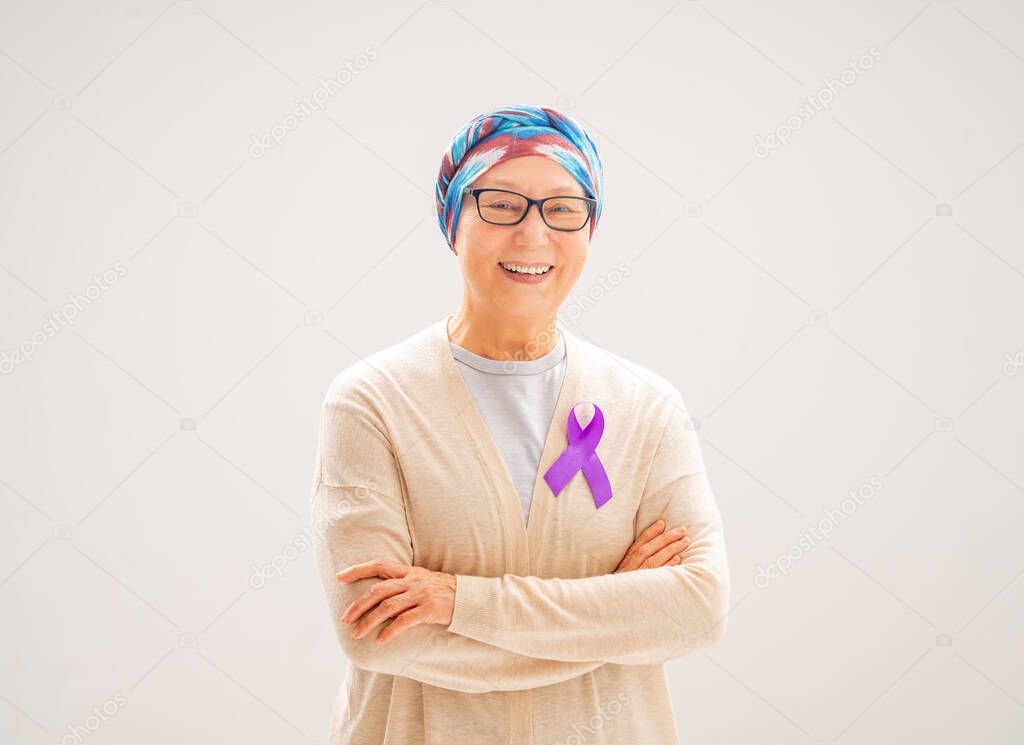 February 4 World Cancer Day. Female patient on grey wall background. Raising knowledge on people living with tumor illness.