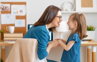 Bilgisayarda çalışan çocuklu genç bir anne. Aile evde. Uzak çalışma. 